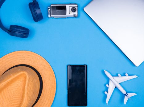 Flat lay top view of traveler bussinesman acccesories over blue background. Phone, hat, Laptop.
