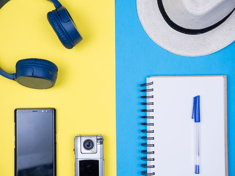 Flat lay top view traveler journal over blue background. Small traveler camera.