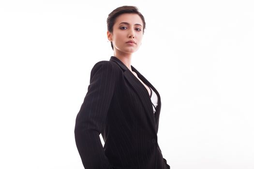 Confident young woman wearing a stylish jacket posing over white background. Fashion style. Costume jacket.