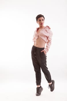 Caucasian fashion model with hand in her pocket and looking on her left posing in studio over white background. Caucasian beautiful woman.