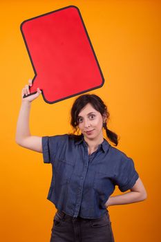 Young beautiful caucasian woman holding an empty tought bubble over her in studio over yellow background. Woman holding empty copy space. Beautiful young woman smiling with thought bubble.