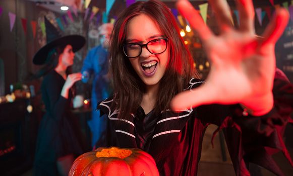 Creepy girl in a halloween costume reaching out for the camera. Monsters gathering for halloween. Beautiful witch.