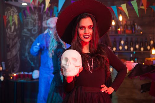 Beautiful young woman dressed up like a with for halloween with a magic hat on her head. Celebrating halloween.