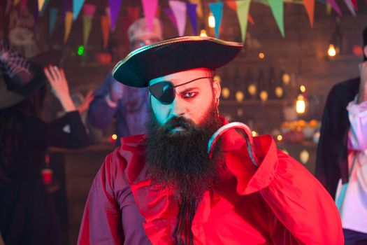 Portrait of man dressed up like pirate looking angry at the camera while celebrating halloween. Halloween costume.