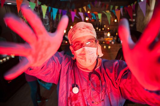 Man dressed up like a doctor having fun at a halloween party. Halloween party in a night club.