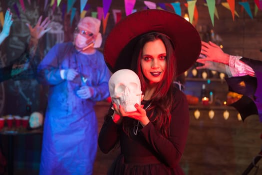 Portrait of beautiful young woman dressed up like a witch for halloween looking deeply into the camera. Halloween celebration.