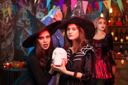 Portrait of two good friends dressed up like witches at a halloween party. Scary witches. Monster celebrating halloween.