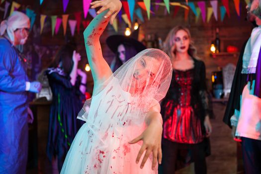 Scary creepy little girl in bride clothes with halloween makeup in weeding dress. Crazy doctor in background.