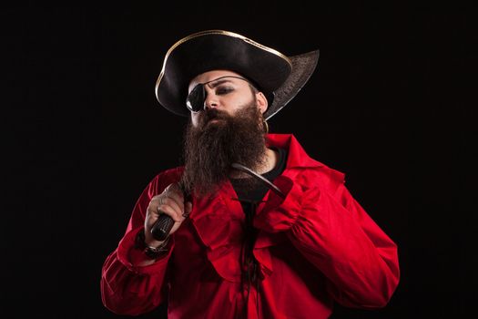 Portrait of handsome bearded man in a pirate costume looking serious into the camera for halloween. Man dressed up like a caribbean pirate.