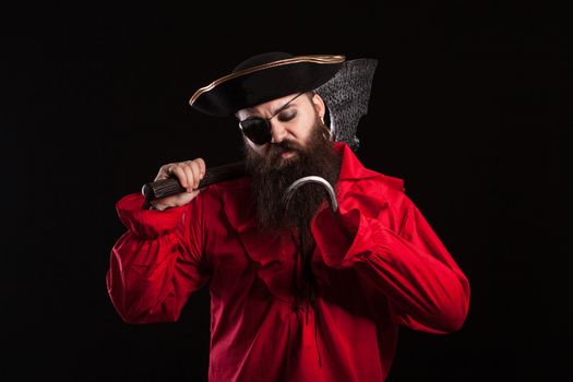 Thoughtful man in a pirate clothes for carnival with a hook insted of his hand. Man dressed up like a carribean robber.