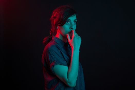 Portrait of beautiful young woman in studio with colored lighting. Attractive caucasian woman. Creative colored lighting. Futuristic lighting.
