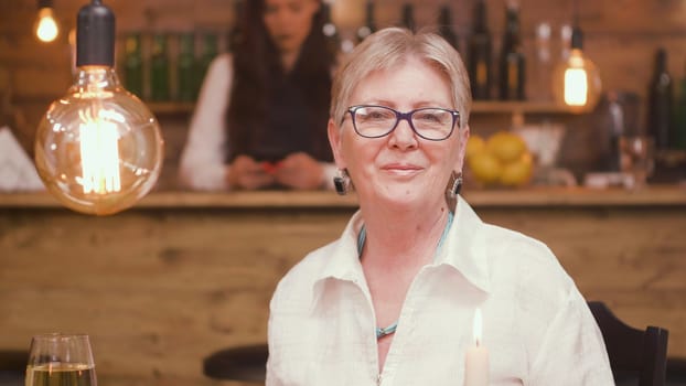 Portrait of senior woman in a restaurant looking at the camera. Relaxed old woman. Woman in her sixties.