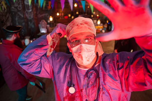 Facial expression of creepy man dressed up like a doctor holding a knife at halloween party. Halloween party in a night club.