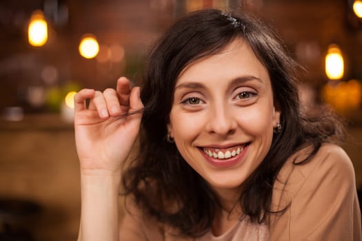 Close up portrait of beautiful woman in a coffee shop smiling at camera. Portrait of happy young woman in a coffee shop.