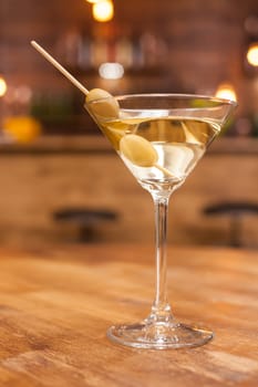 Alcoholic martini cocktail on a rustic wooden table in a restaurant. Fresh drink. Relaxing drink.