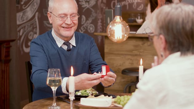 Senior man asking his wife to mary him again after all of this years of marriage. Old couple. Couple in their sixties.