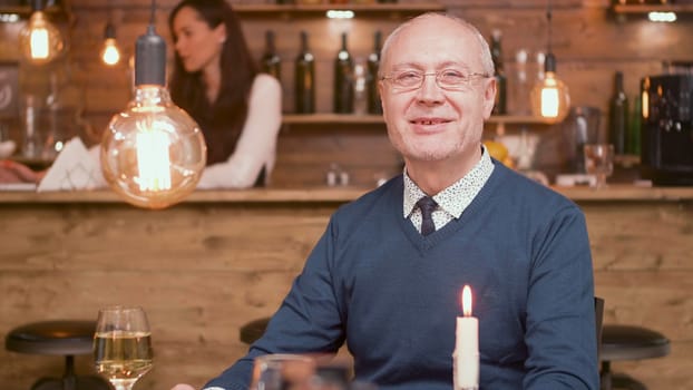 Portrait of senior man in a restaurant smiling at the camera. Man in his sixties. Happy old man.