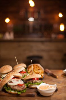 Food composition of bugers variety on a wooden table. Vintage restaurant. Grilled beef. Fast food.