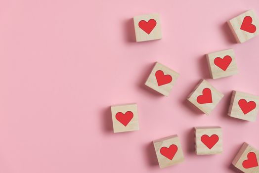Heart in Wooden cubes on pink background with copy space. Standing out, Contrast, Difference, Valentine's day concepts.