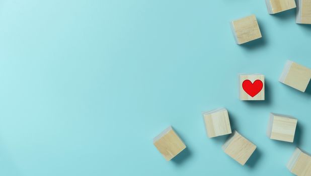 Heart in Wooden cubes on blue background with copy space. Standing out, Contrast, Difference, Valentine's day concepts.