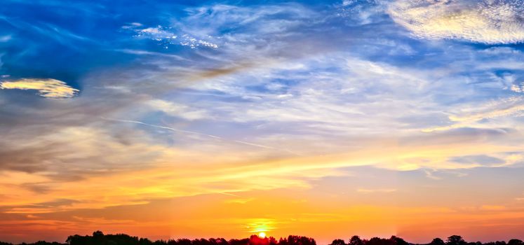 Beautiful high resolution panorama of orange and red sunset clouds in the evening sky.