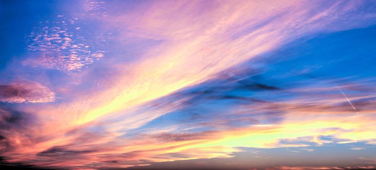 Beautiful high resolution panorama of orange and red sunset clouds in the evening sky.