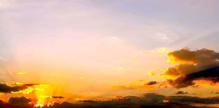 Beautiful high resolution panorama of orange and red sunset clouds in the evening sky.