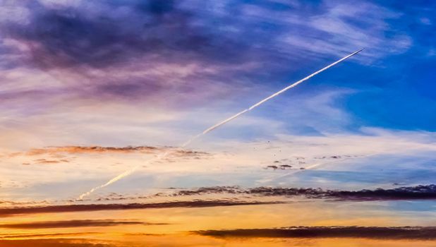 Beautiful high resolution panorama of orange and red sunset clouds in the evening sky.