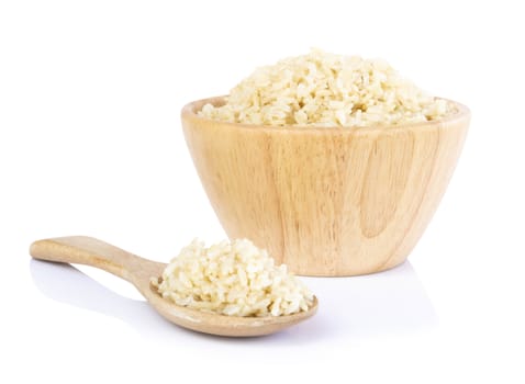 Brown rice in the wood bowl and spoon isolated on white background, healthy food conept