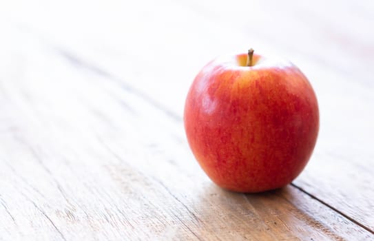 Closeup fresh red apple fruit on wood table background with light from out door, food healthy diet concept