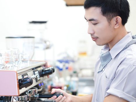 Closeup asian man barista preparing for making coffee at cafe with happy feeling