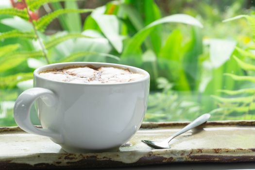 Close up glass of hot coffee with green nature background