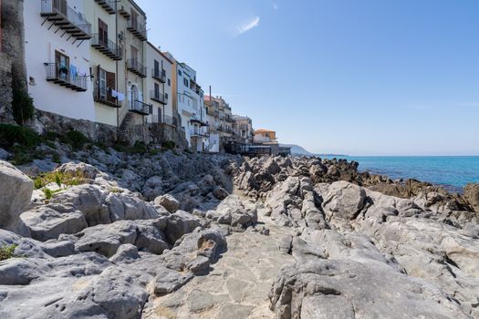 View over the coastline and residential buildings from Bastione di Capo Marchiafava bastion lookout point on a sunny day in Cefalu - Sicily, Italy.