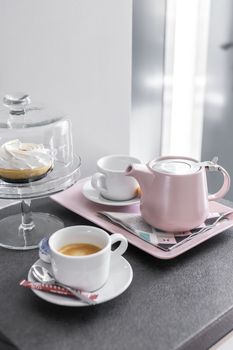 Coffee pot and cups setup on a tray and dessert cake in bright light mood - still life.