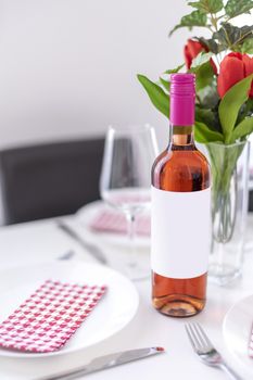 Mockup of a standing rose wine bottle on a dining table in natural daylight.