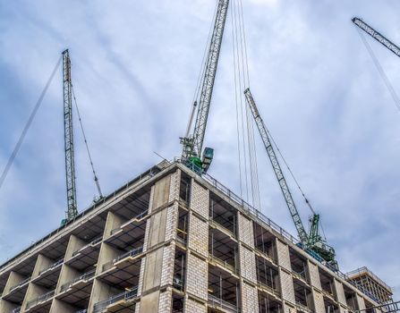 Several cranes on constructions sites at high buildings all over Europe.