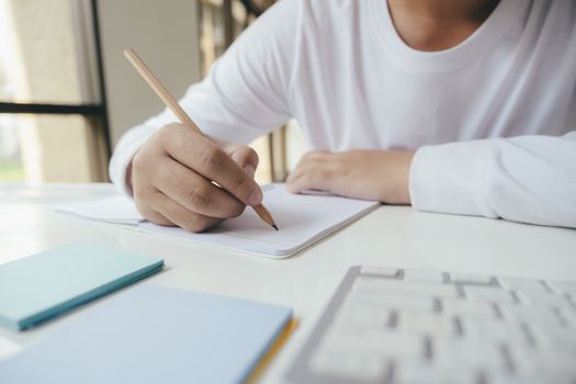 Close up hands with pen writing on notebook. Education concept.