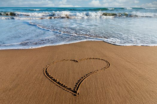 Drawing heart on the sand