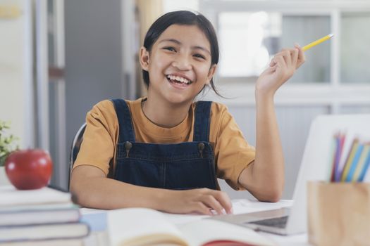 Happy asian girl learning online at home. Education and e-learning concept.