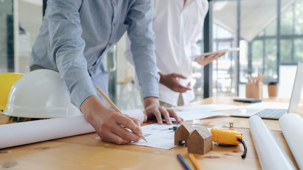 Image of engineer meeting for architectural project working with partner and engineering tools on workplace.