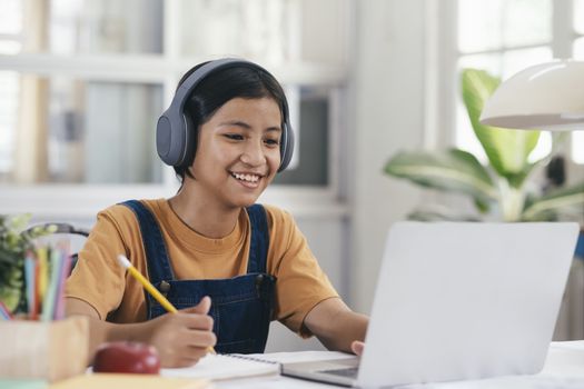 Happy asian girl learning online at home. Education and e-learning concept.