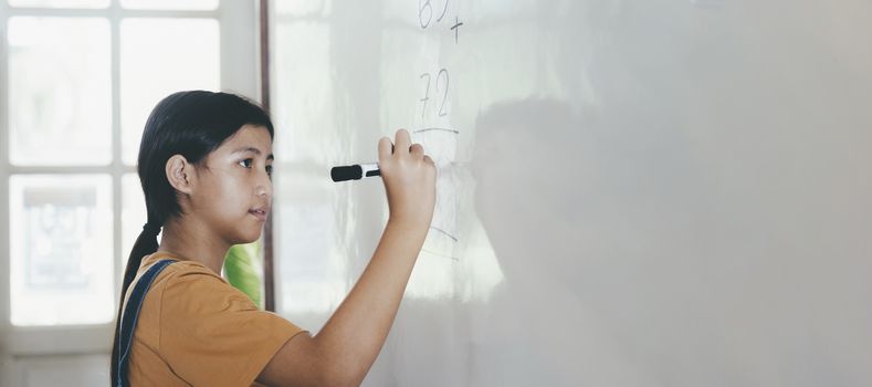 School child thinking while doing mathematics problem. Education concept.