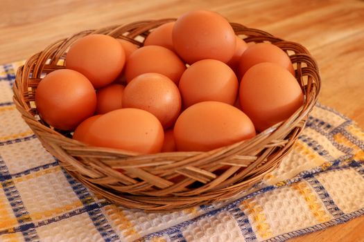 Brown chicken egg on vintage tablecloth and eggs in the basket.