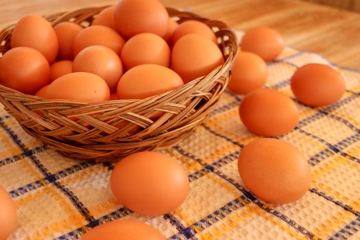 Brown chicken egg on vintage tablecloth and eggs in the basket.