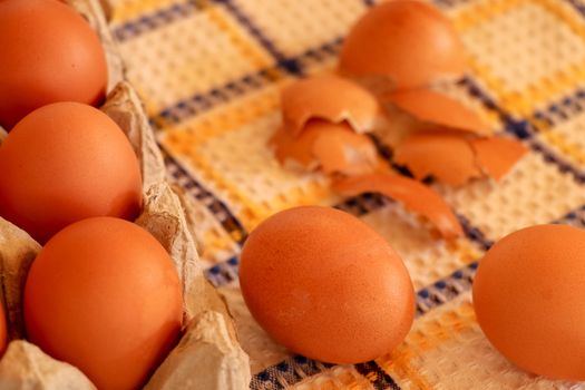 Brown chicken egg on vintage tablecloth and eggs in the basket.