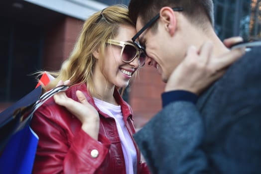 Portrait of a couple with shopping bags in the city.People, sale, love and happiness concept.