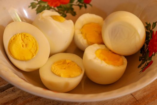 close up of half boiled eggs on wooden bowl.