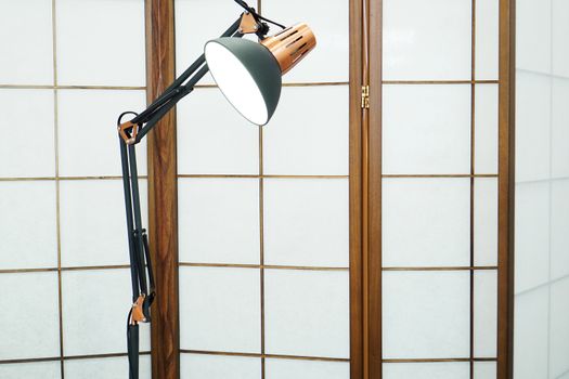 Screen with wooden inlays in a beauty salon. Metal lamp