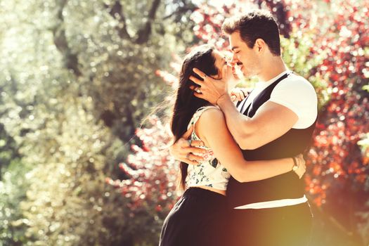 Young couple loving outdoors in a park. A young man and young woman embracing e kissing with passion and feeling. Love and falling in love. Black and white