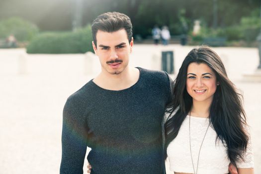 Beautiful embracing lovely young italian couple outdoors. A couple, young man and a smiling woman outdoors.